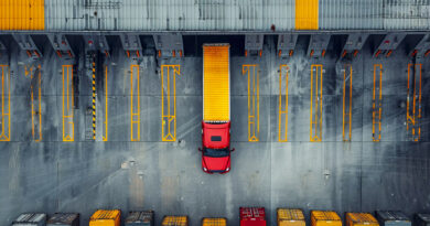 Processo de baldeação de cargas em hub logístico, com caminhões e equipamentos transferindo mercadorias entre veículos.