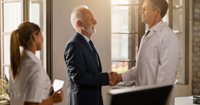 Executivo entregando cartão de premiação a colaborador sorridente, representando premiação sem encargos no ambiente corporativo.